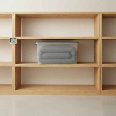 A neatly folded air mattress inside a clear protective plastic bin, stored on a shelf in a clean, organized storage room.